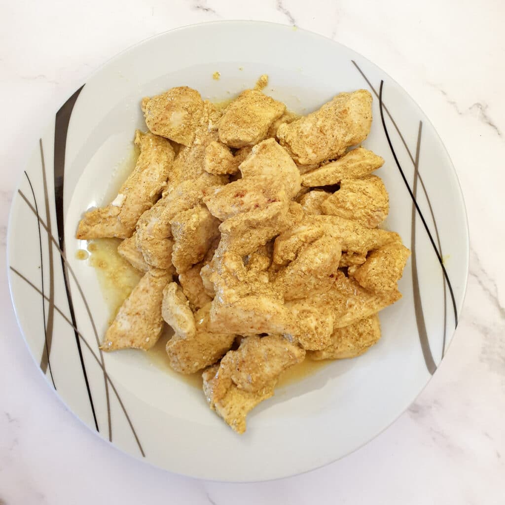 Cooked chicken breast pieces on a plate.
