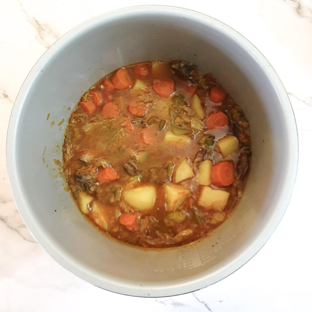 Overhead shot of a fully cooked lamb stew in a pressure cooker.