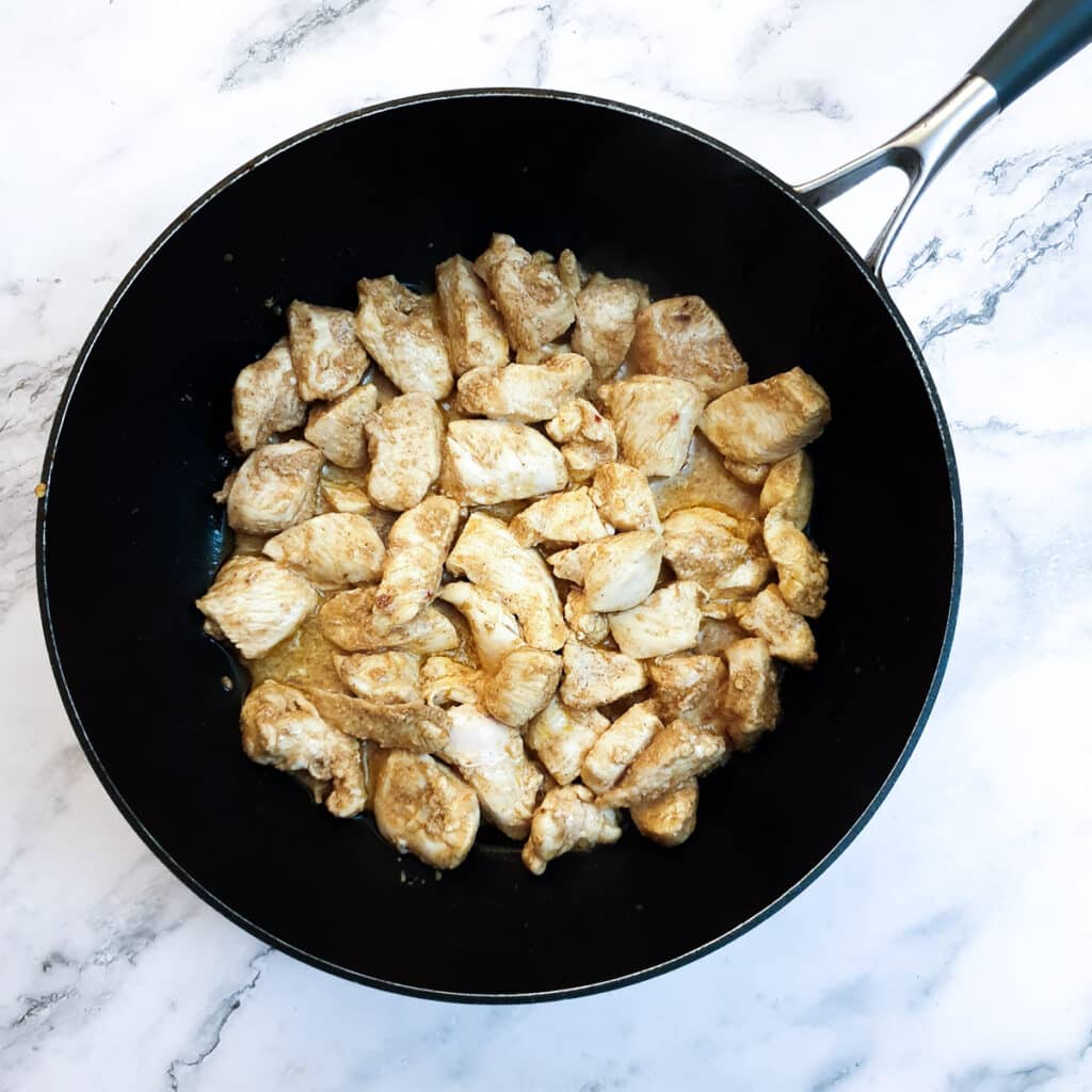 A frying pan containing all the cooked chicken pieces.