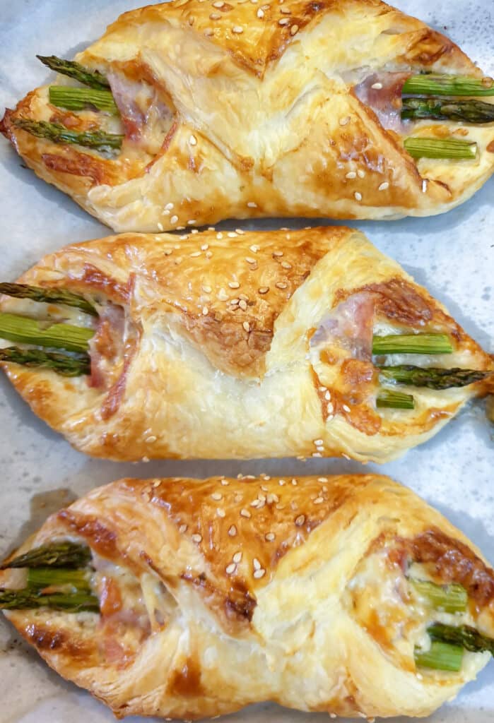 Overhead shot of 3 baked ham and asparagus bundles.