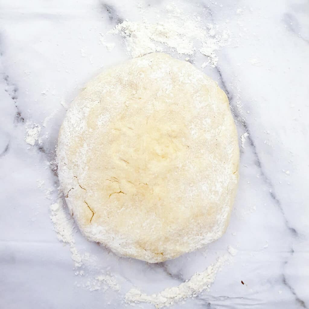 A ball of yoghurt pastry on a floured surface.