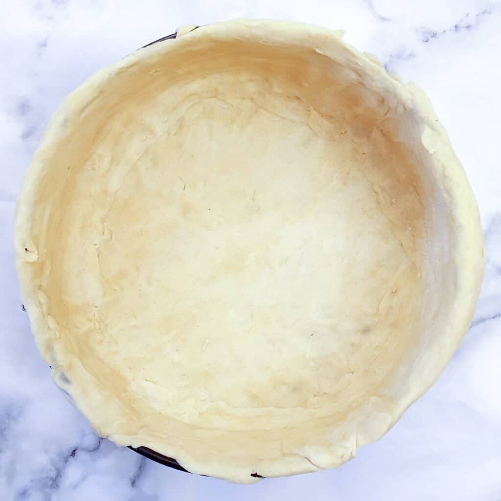 A springform pan lined with pastry.