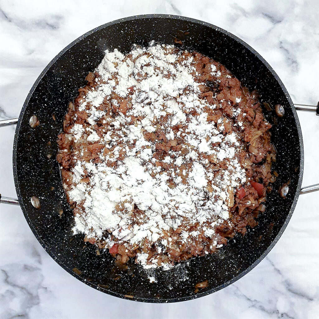 Flour sprinkled on top of the minced been filling.