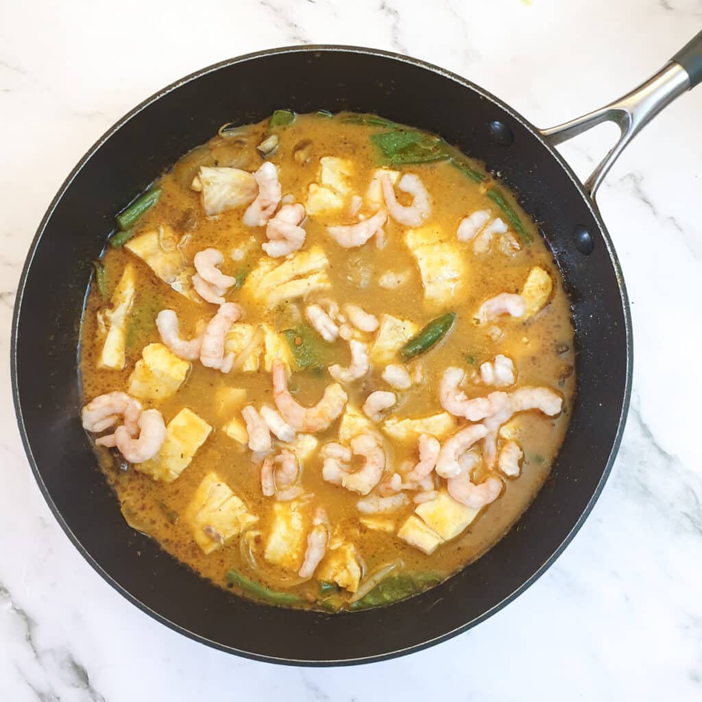 Cooked prawns sprinkled over the Thai red curry.
