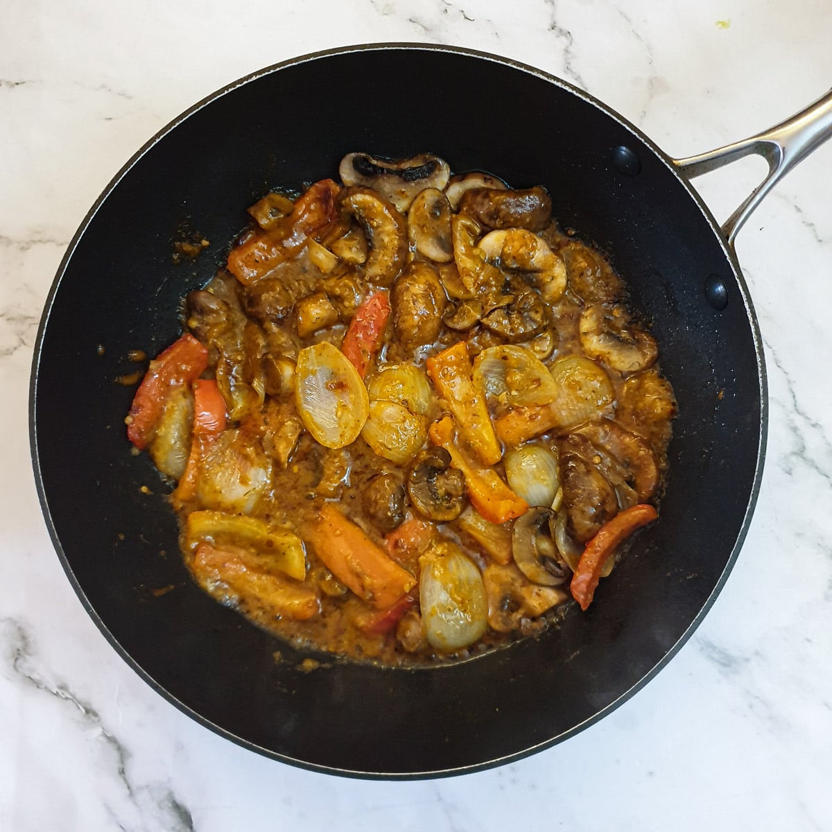 Thai curry spices added to the vegetables in a pan.