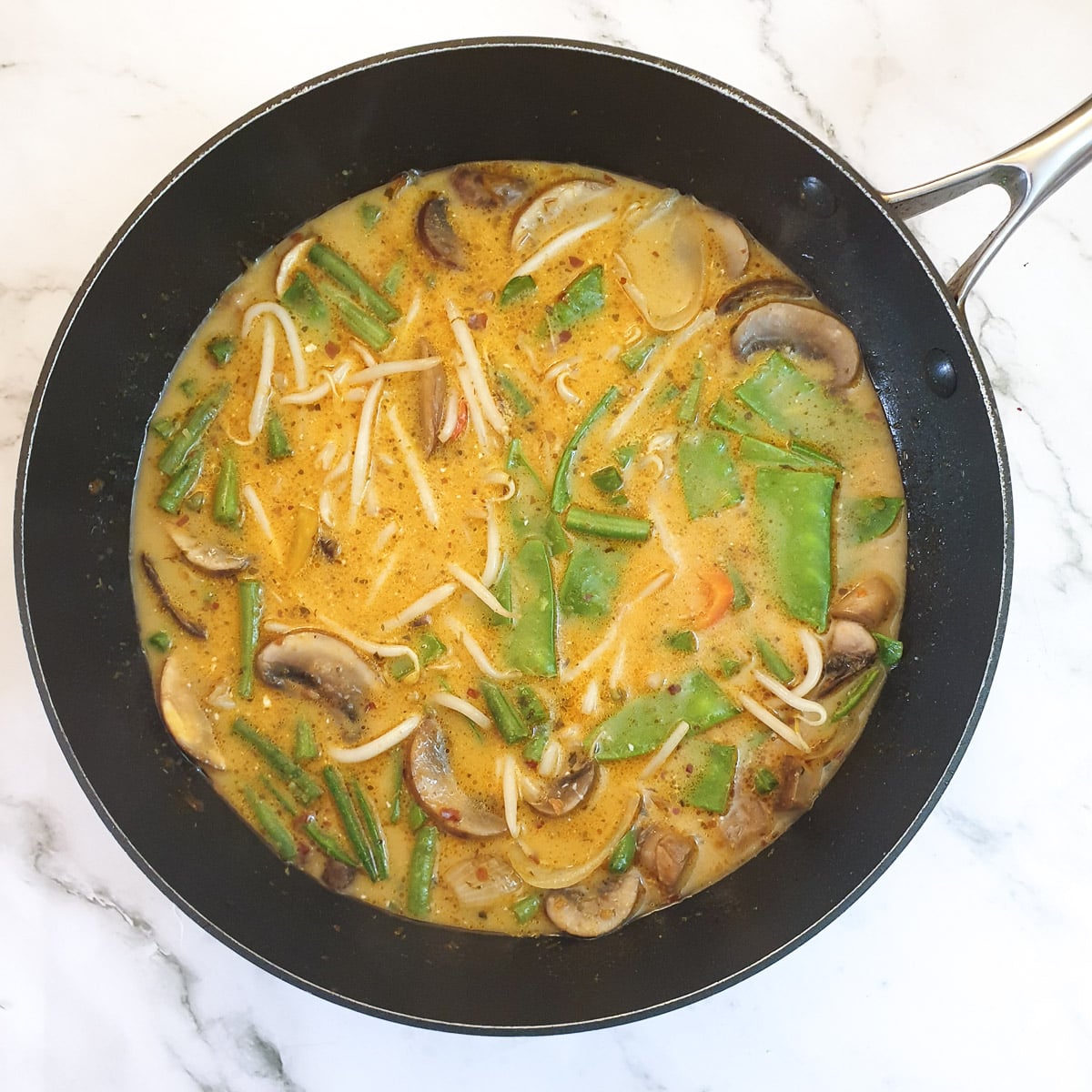 Stock and the remaining vegetables added to the Thai red curry.