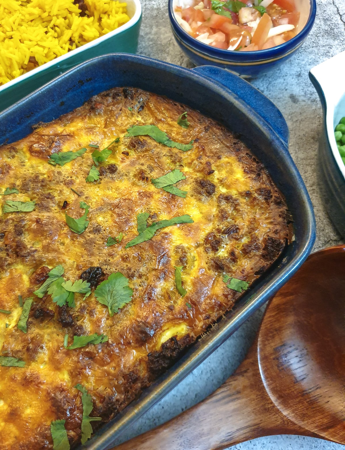 Close up of a dish of bobotie garnished with chopped coriander.