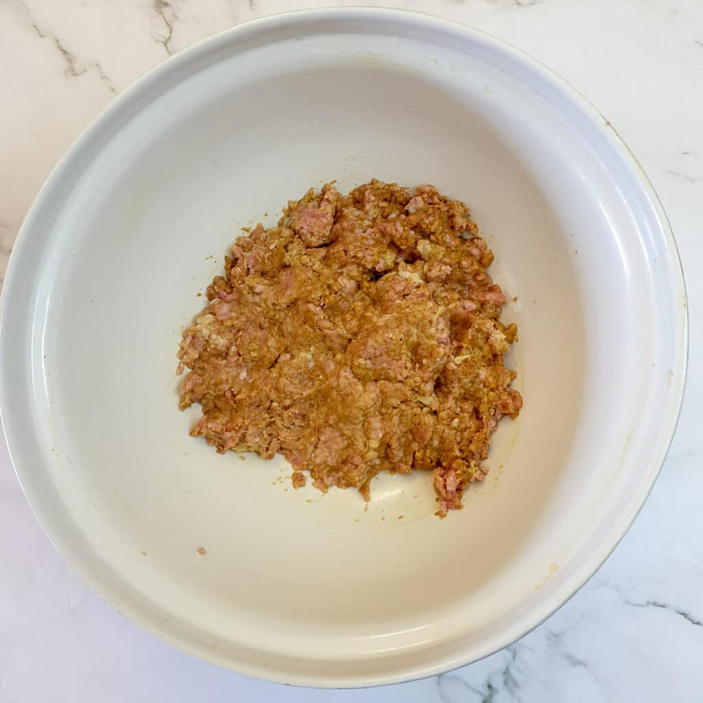 Bobotie mince mixed with spices and ready for frying.