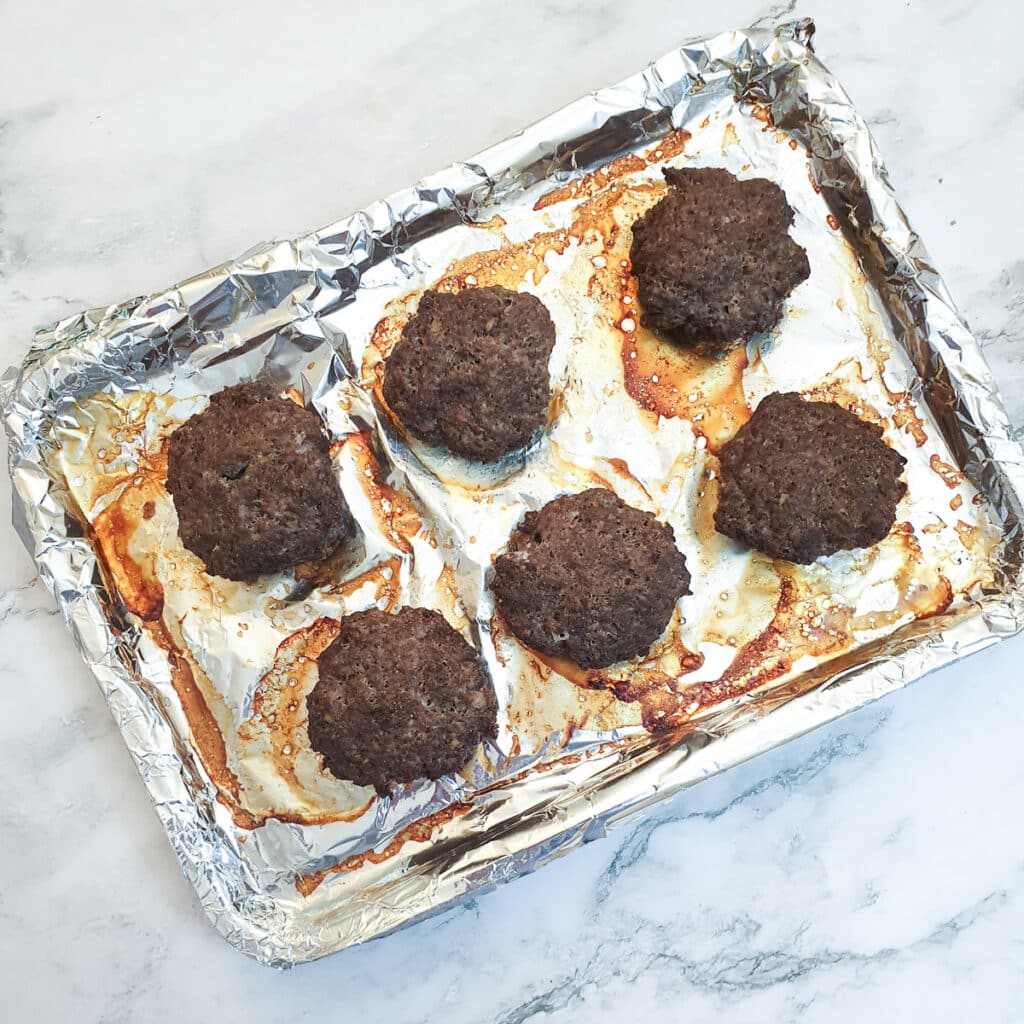 6 cooked boerewors patties on a baking tray.