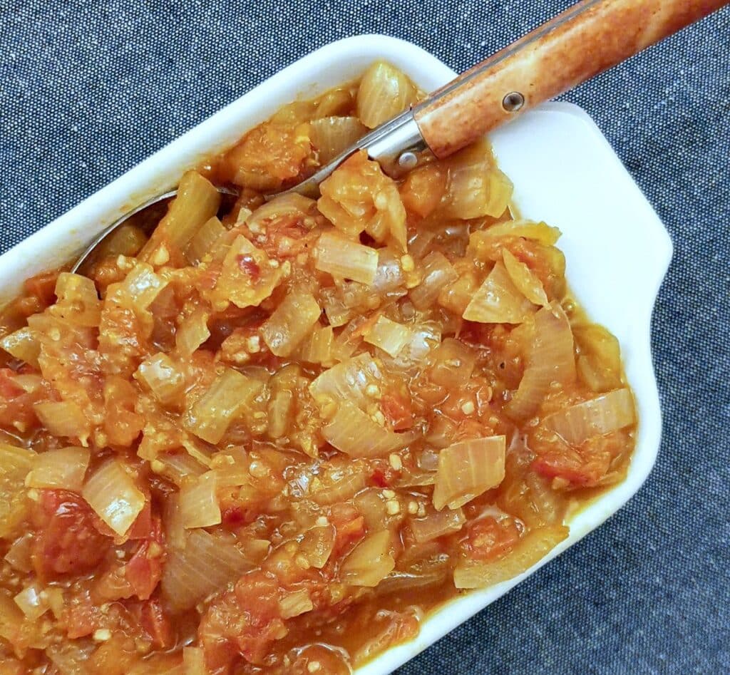 A serving dish of tomato and onion sauce.