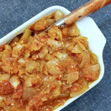 A serving dish of tomato and onion sauce.