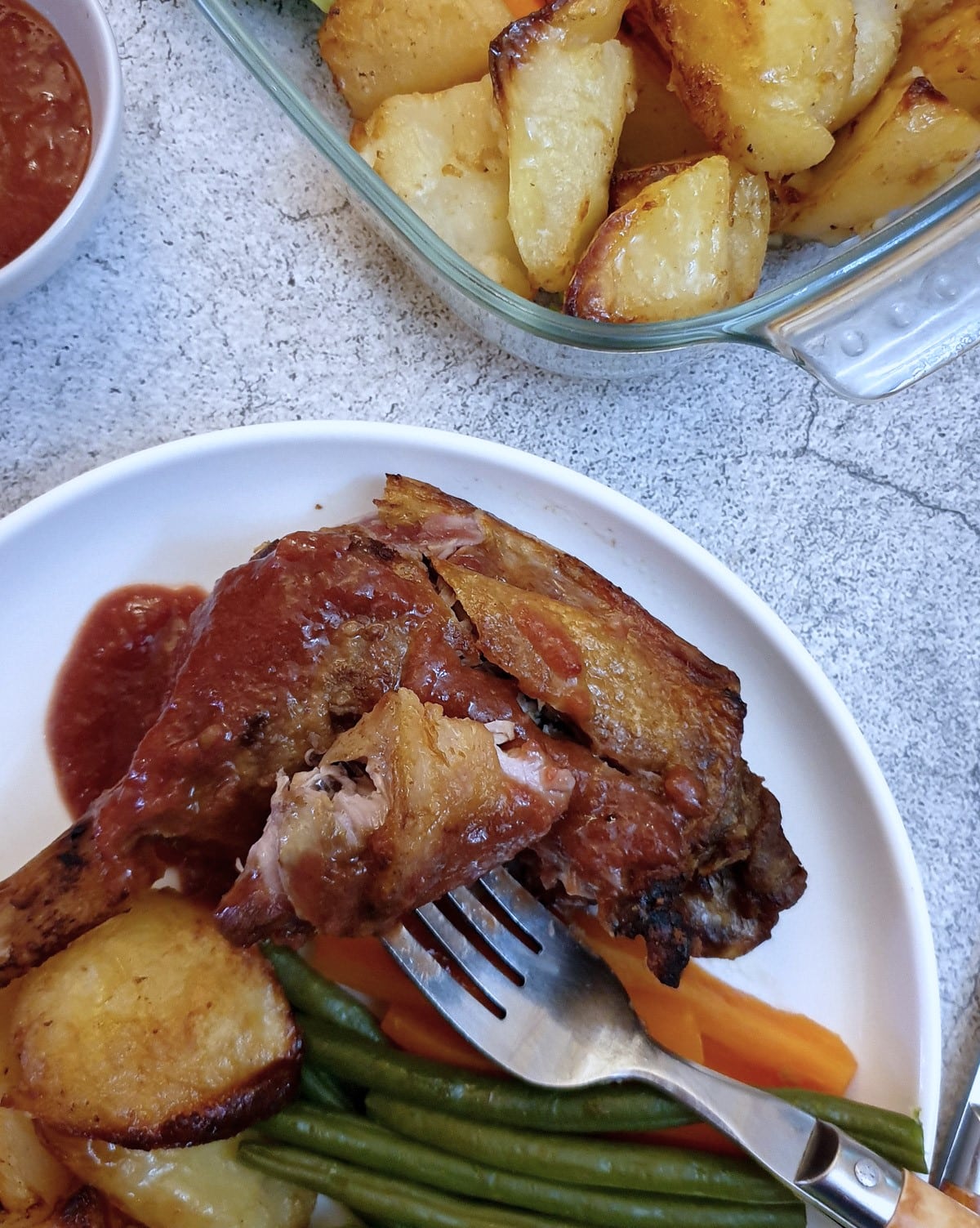 Close up of a duck leg with a piece of leg on a fork.