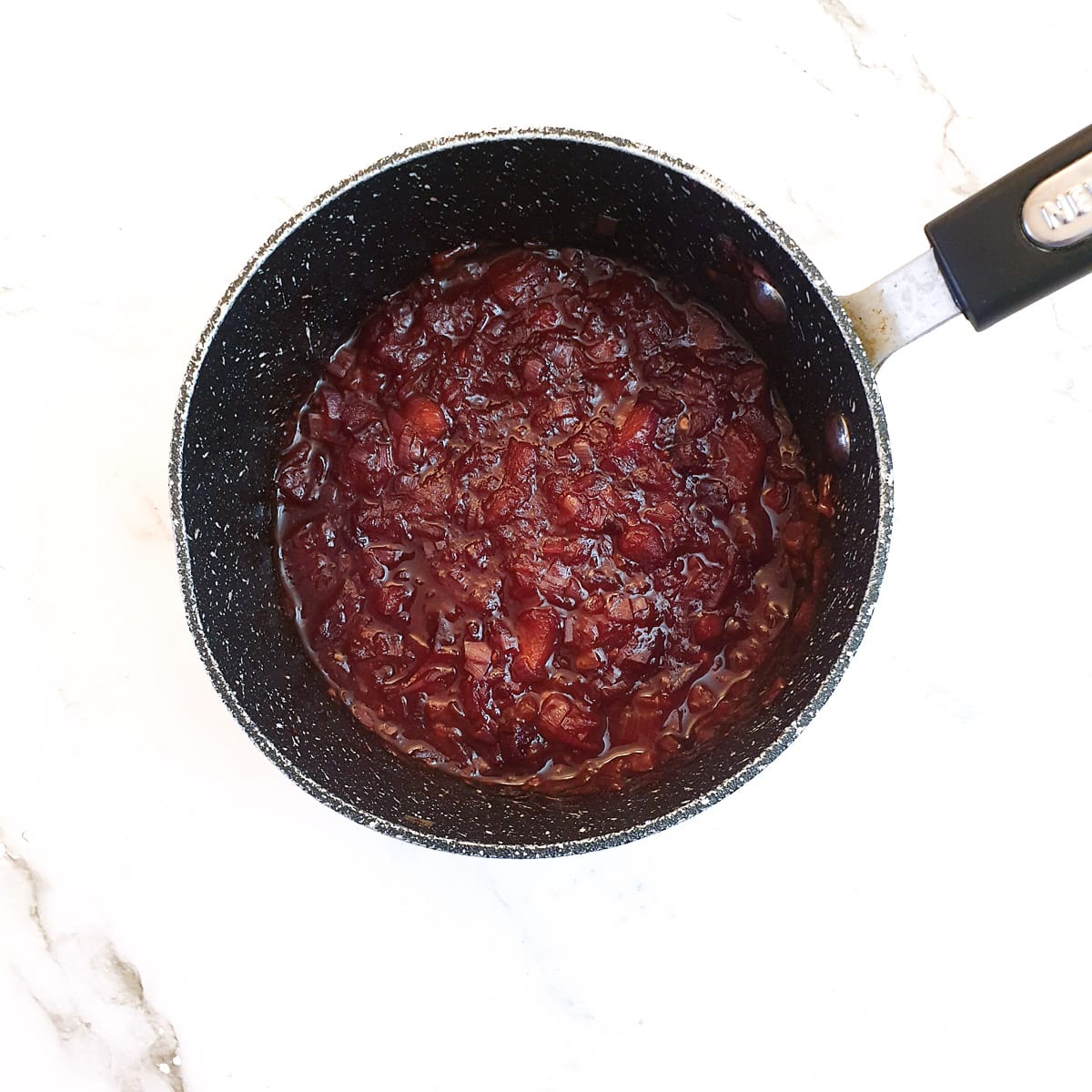 A saucepan of cooked plum sauce before being blended.