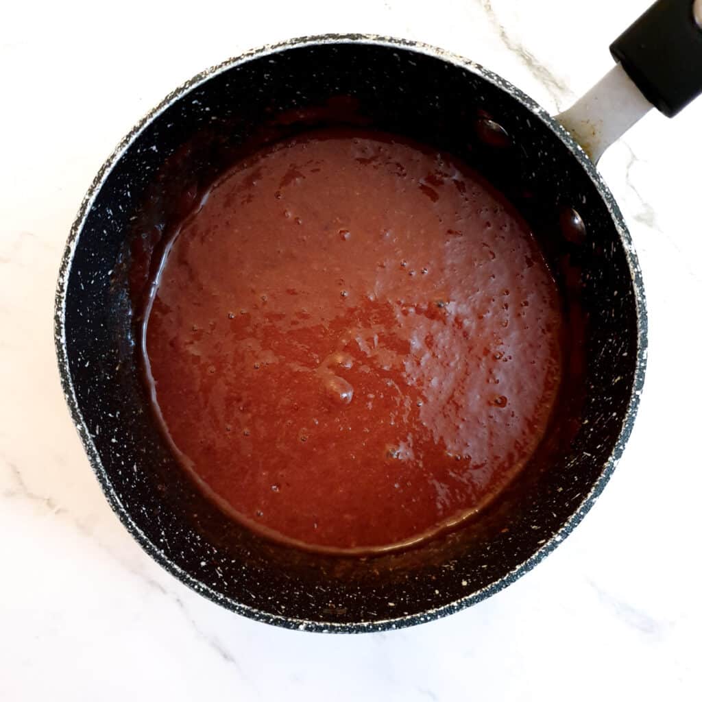 A saucepan of plum sauce after being blended.