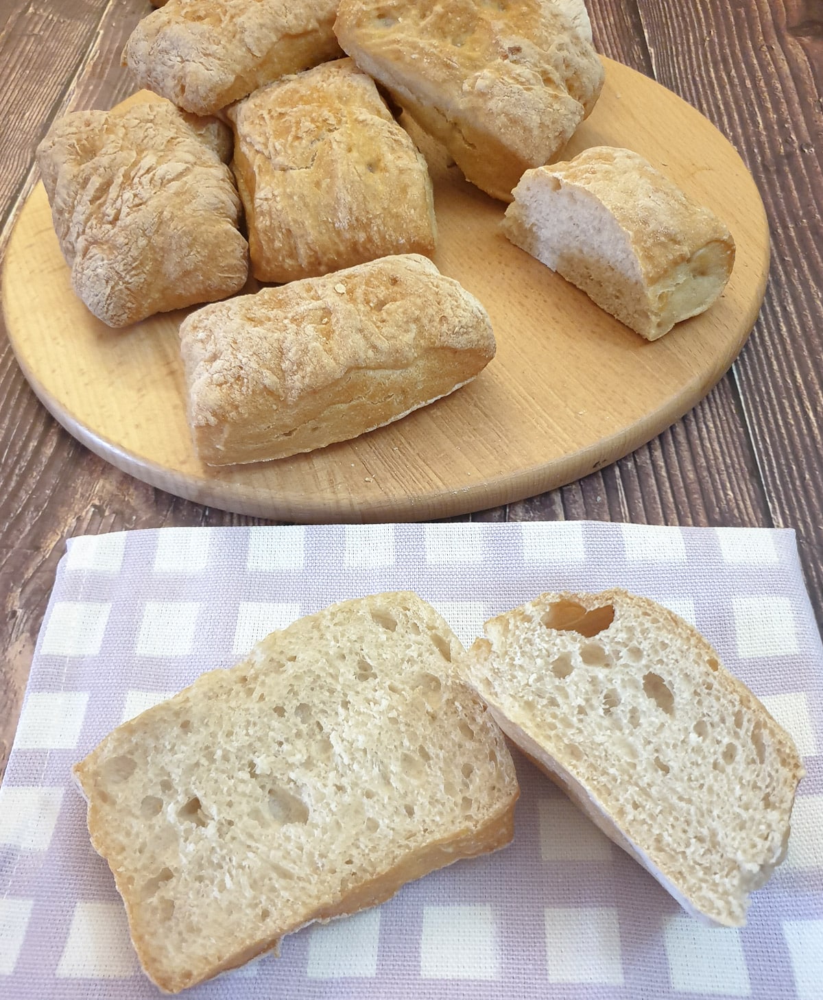 Ciabatta cut in half on a purple checked cloth.