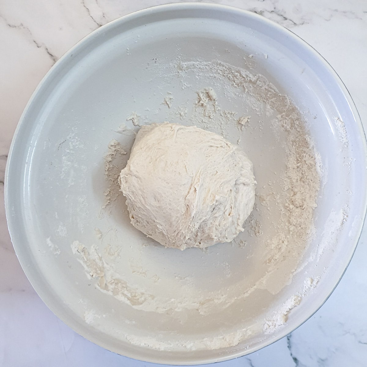 A ball of ciabatta dough after it has been folded on itself.