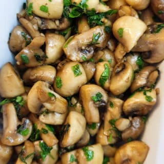 Close up of a dish of garlic mushrooms.
