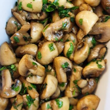 Close up of a dish of garlic mushrooms.