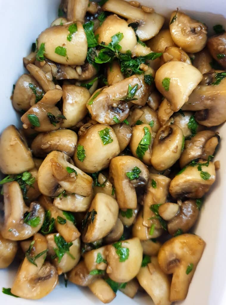 Close up of a dish of garlic mushrooms.
