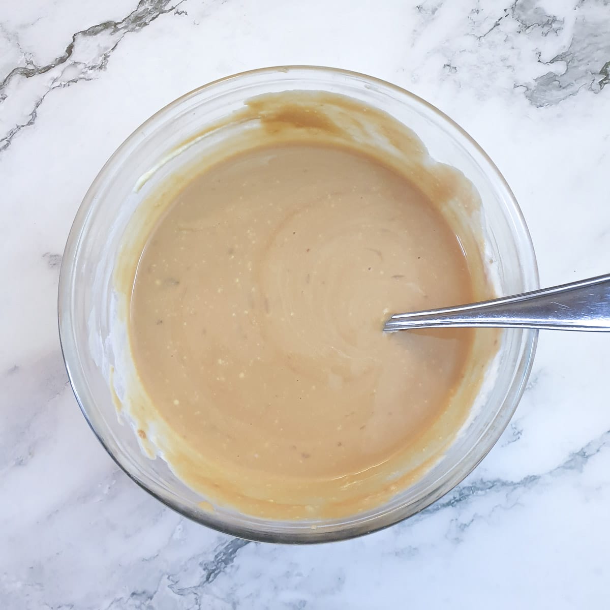 Caramel condensed milk and whipped cream combined in a glass bowl.