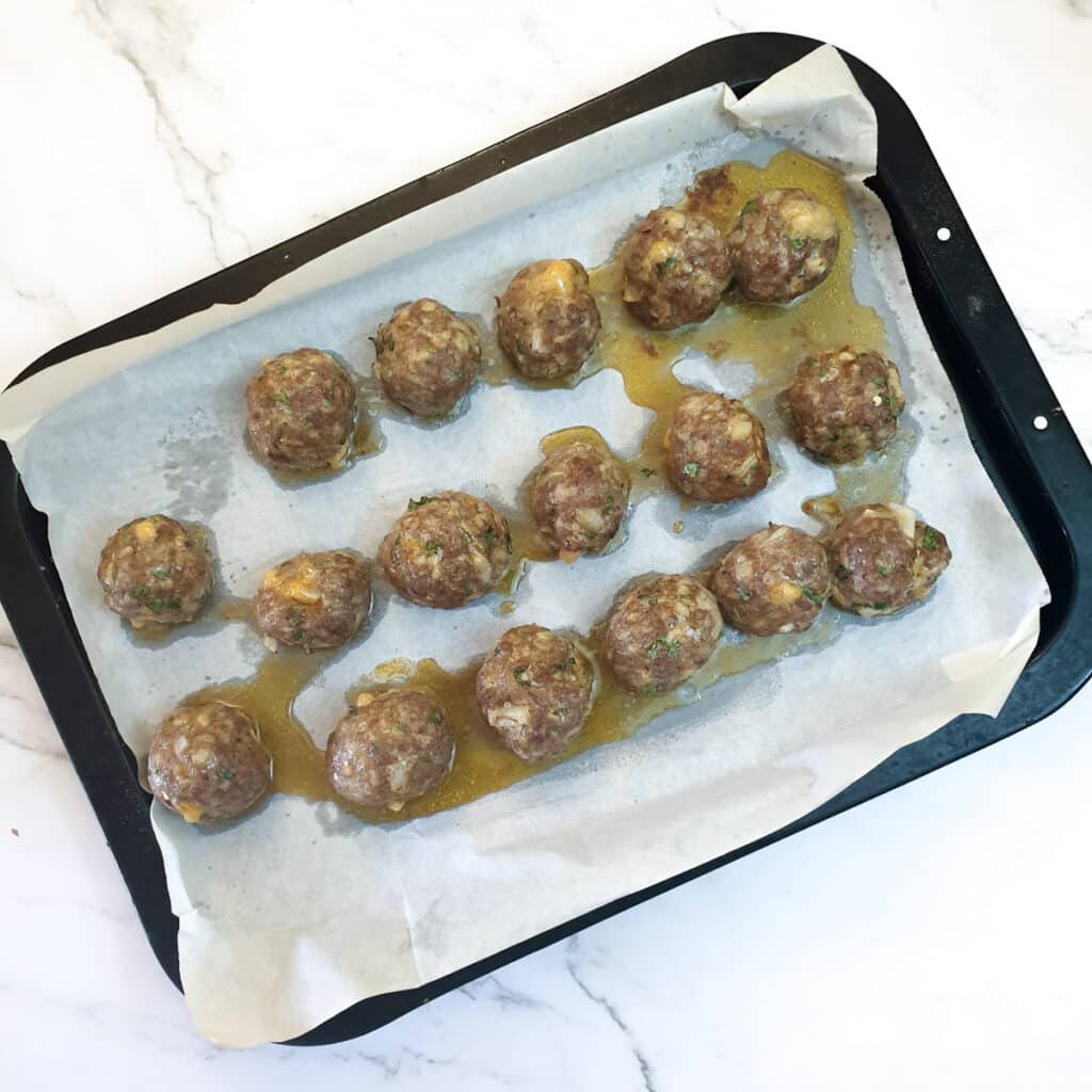 Baked meatballs on a baking tray.