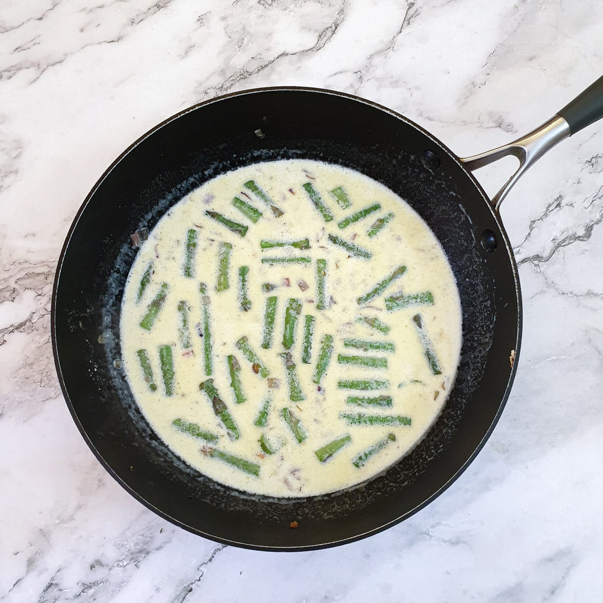 Milk and cream being thickened with shallots and asparagus.