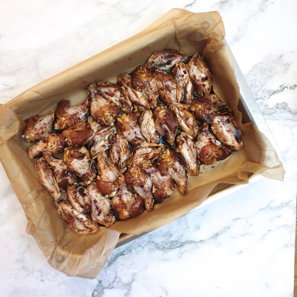 Chicken wings arranged in a single layer in a baking dish.