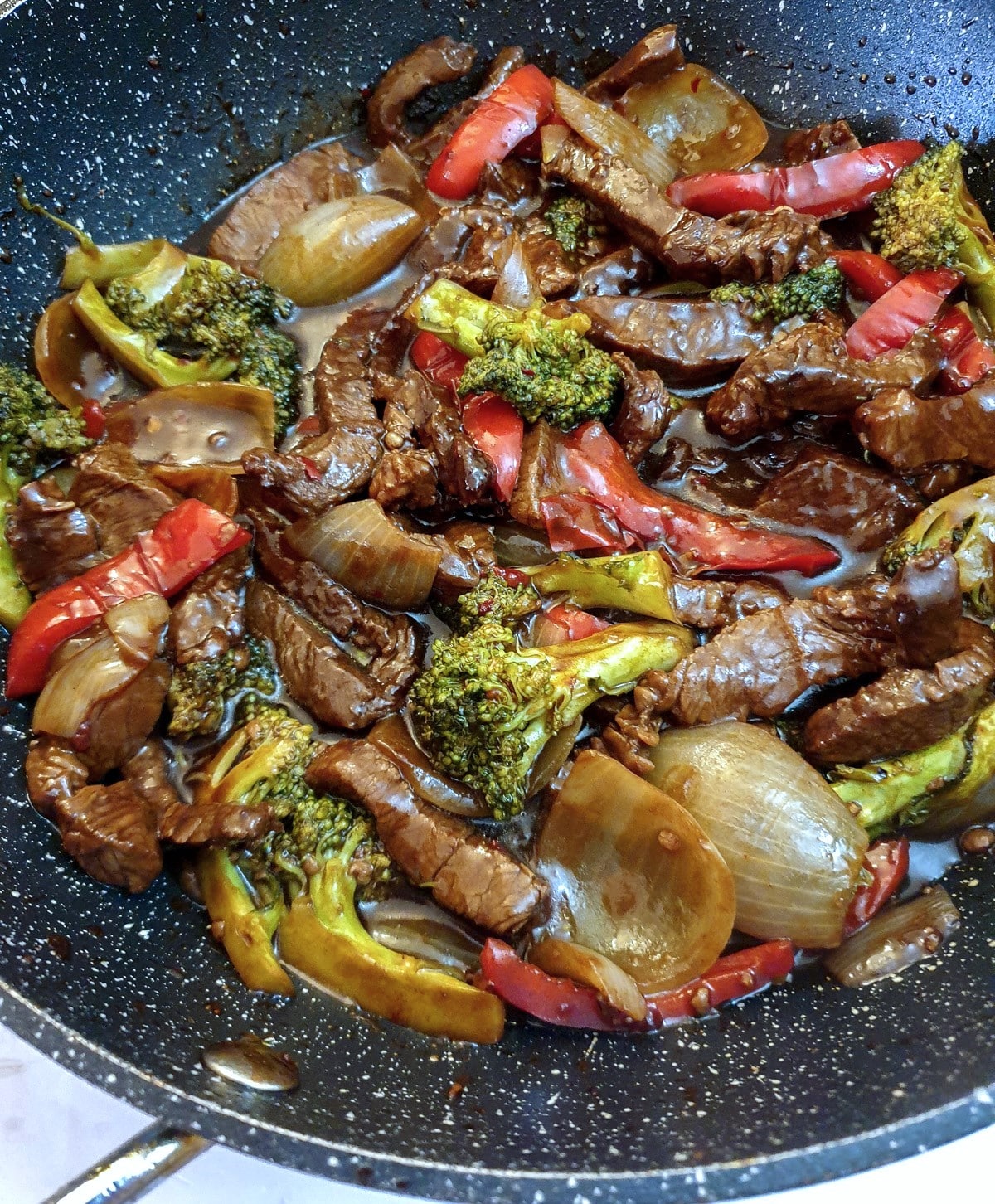 Close up of a frying pan containing Szechuan beef stirfry.