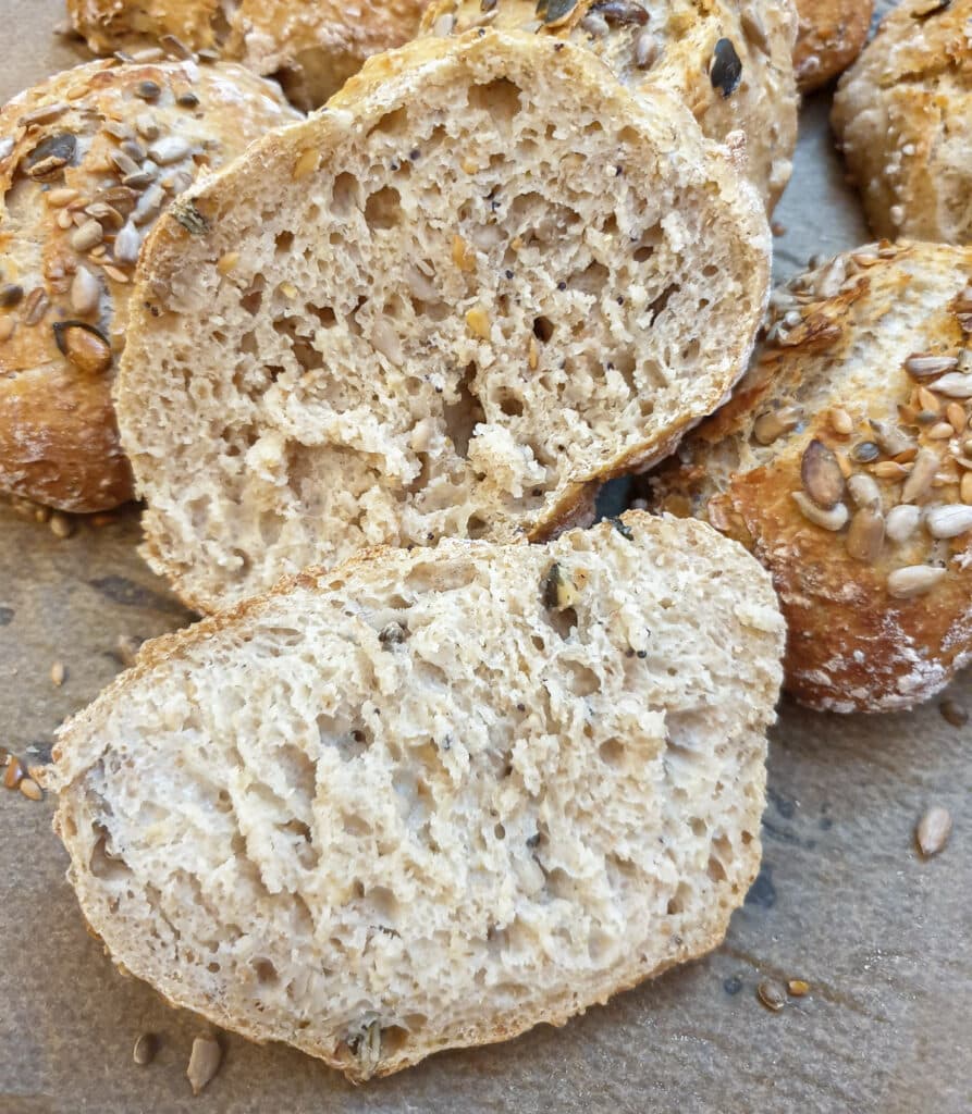 Close up of a seeded bread roll cut in half to show the texture.