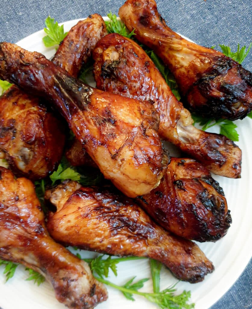 Closse up of a pile of golden brown air fried chicken drumsticks.