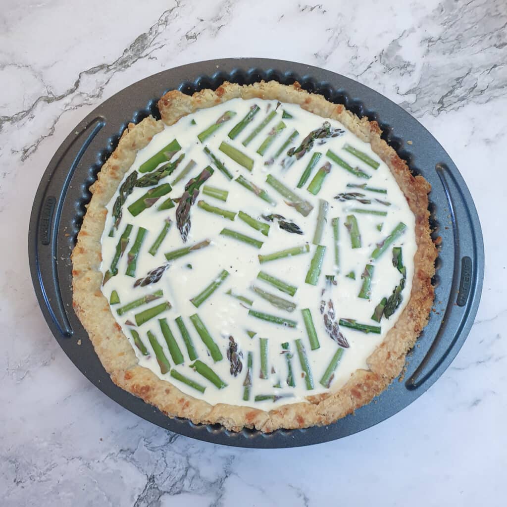 Chopped asparagus in a pastry shell covered with cream and eggs.