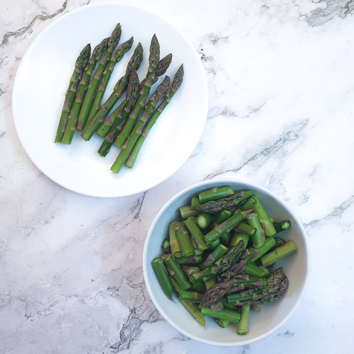 Chopped asparagus on a white plate.