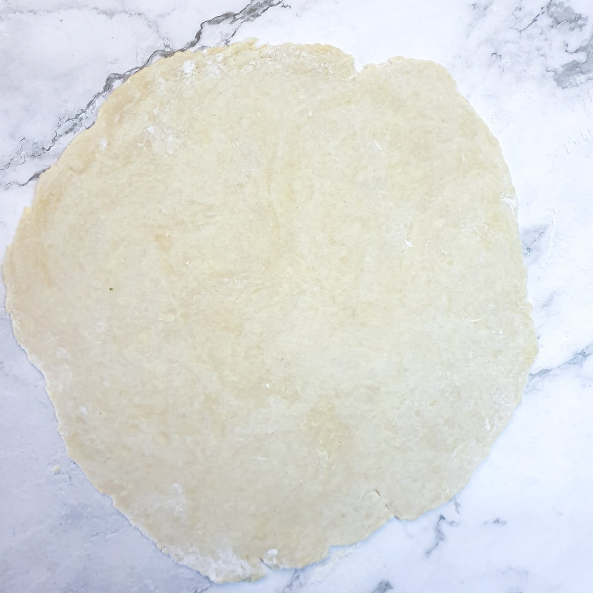 Pastry on a work surface rolled into a circle.