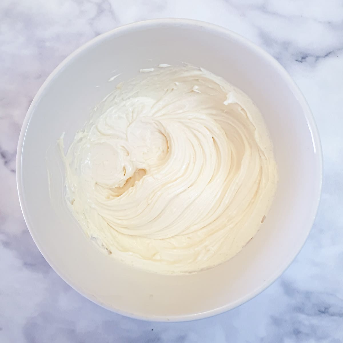 Mascarpone cheese, sugar and egg yolk beaten until smooth in a mixing bowl.