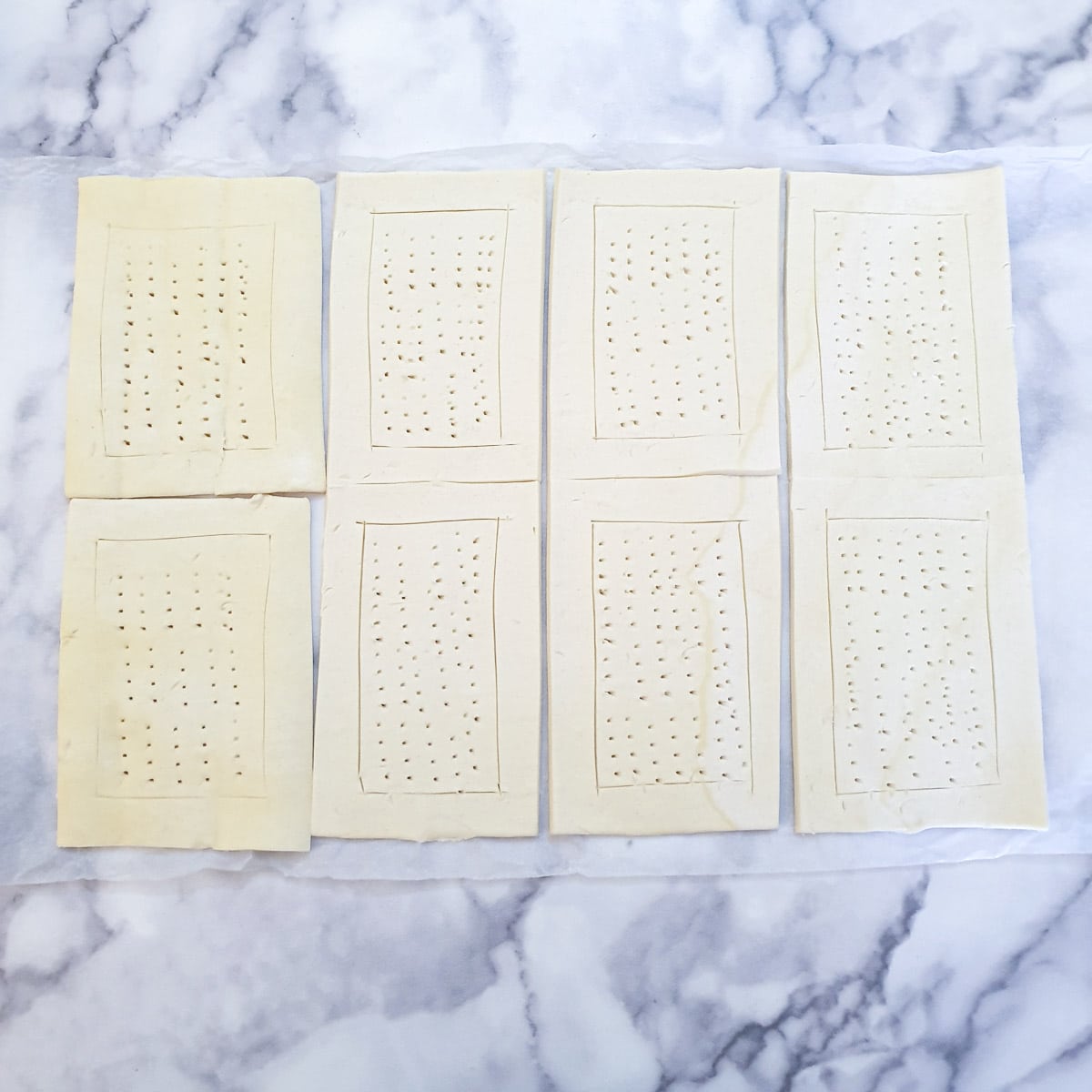 Puff pastry rectangles scored with a knife and pricked with a fork.