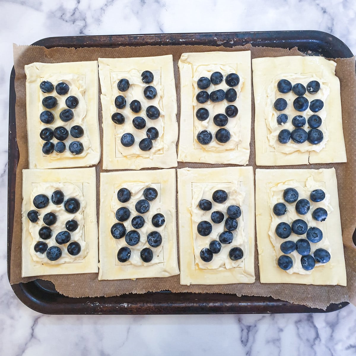 8 blueberry cream cheese Danish pastries ready to go into the oven.