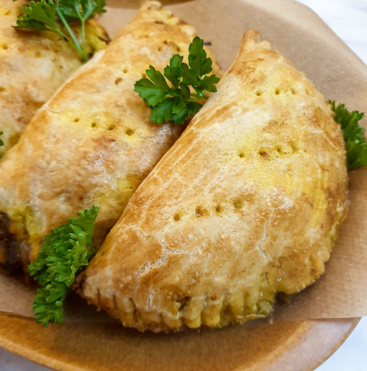 Closeup of a curried chicken pie on a plate.