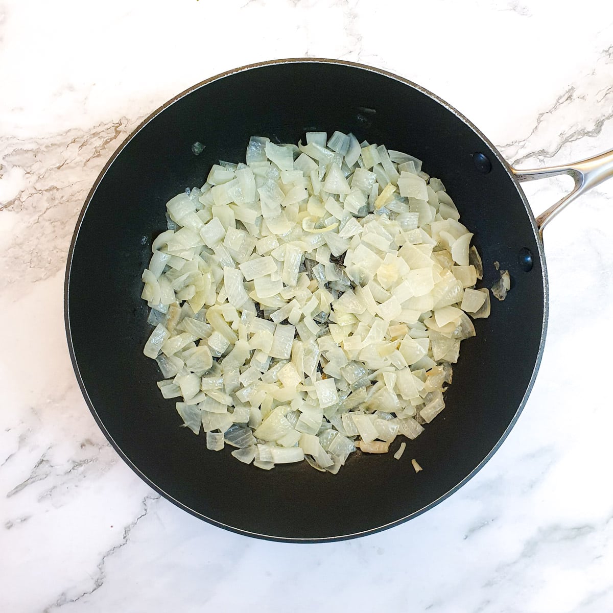 Chopped onions and garlic in a frying pan.