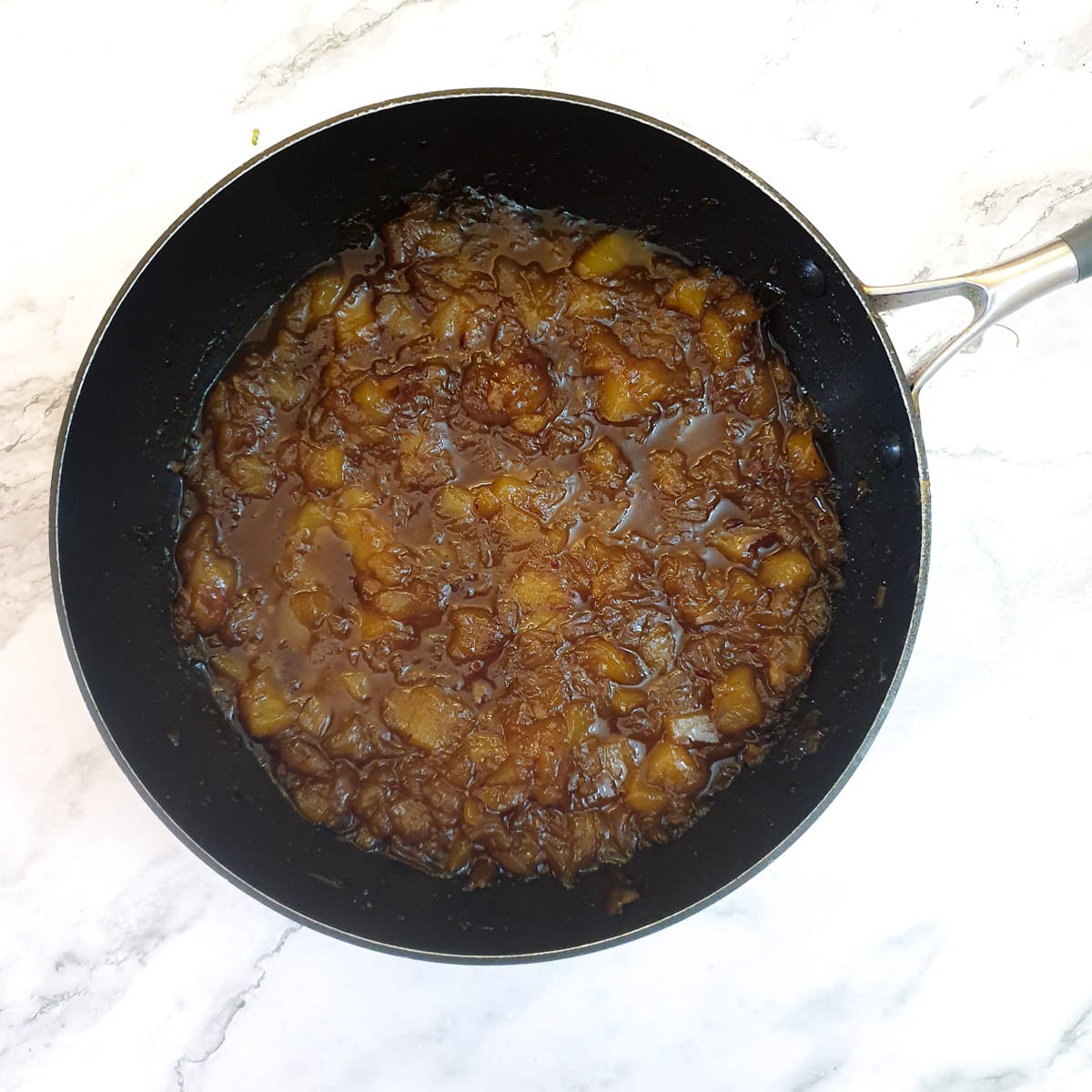 A frying pan of sticky mango chutney.