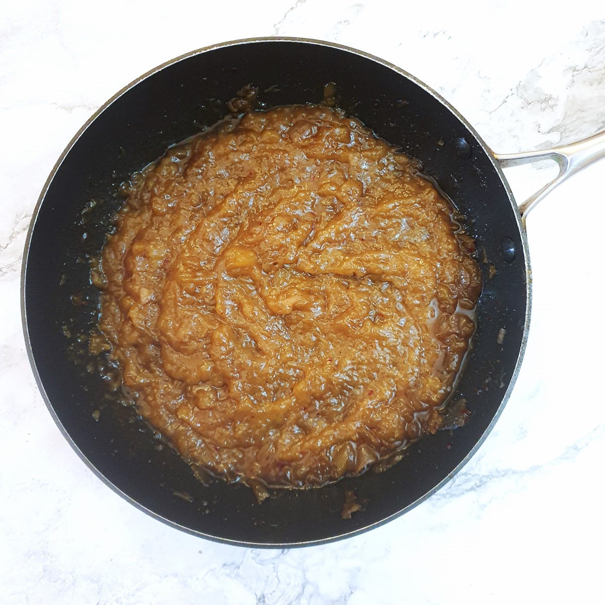 Mango chutney in a frying pan after being blended.