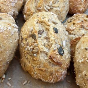 Close up of a baked seeded bread roll.