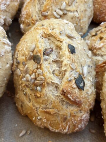 Close up of a baked seeded bread roll.