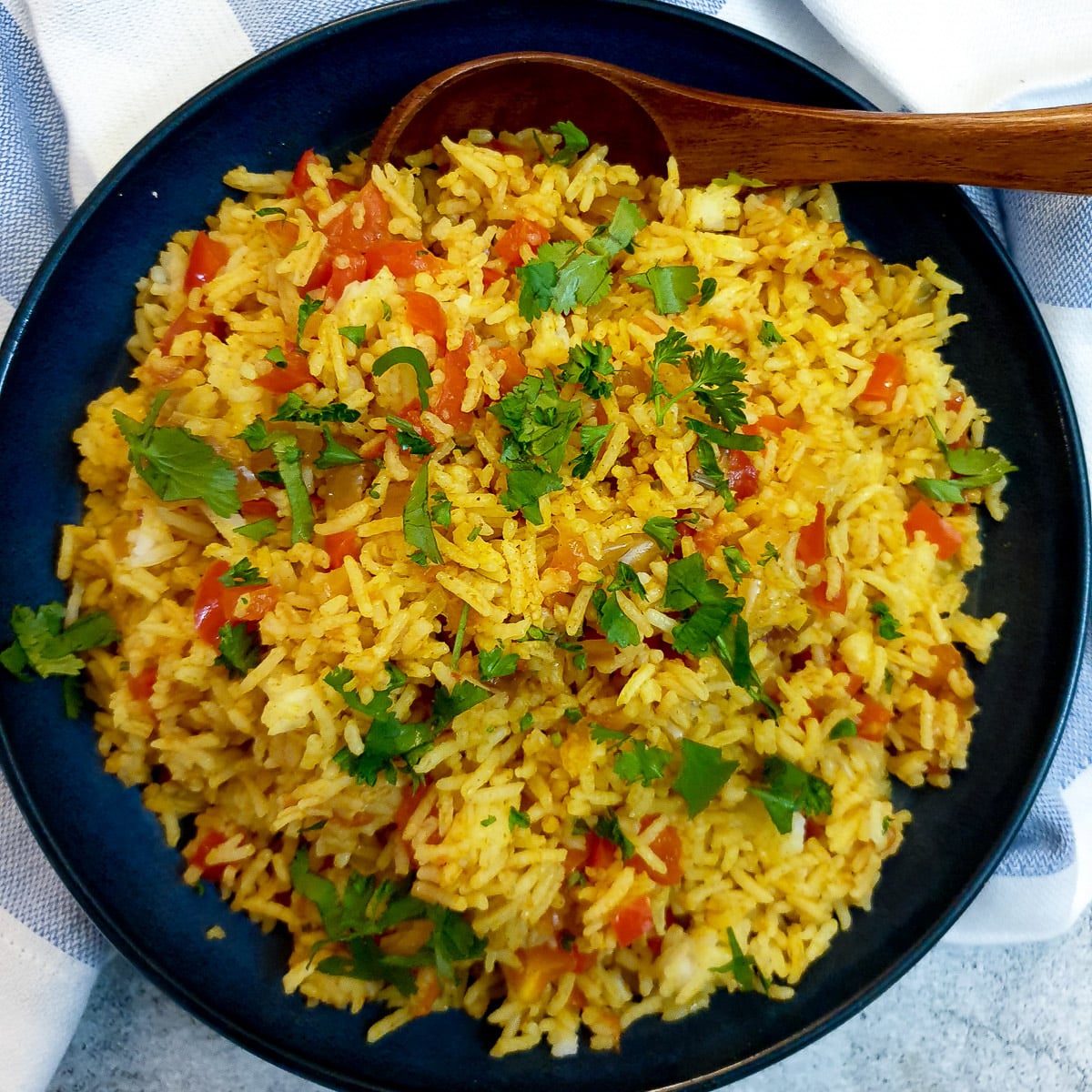 A serving dish of spicy Moroccan rice garnished with chopped parsley.