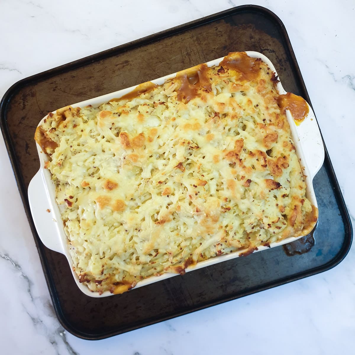 A browned dish of sausage cottage pie.