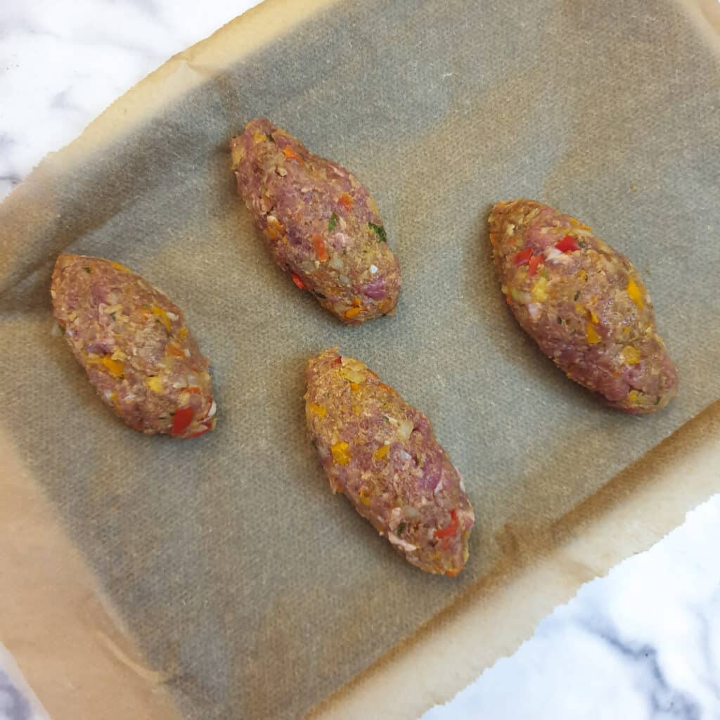 4 small lamb kofta formed into shapes without being skewered.