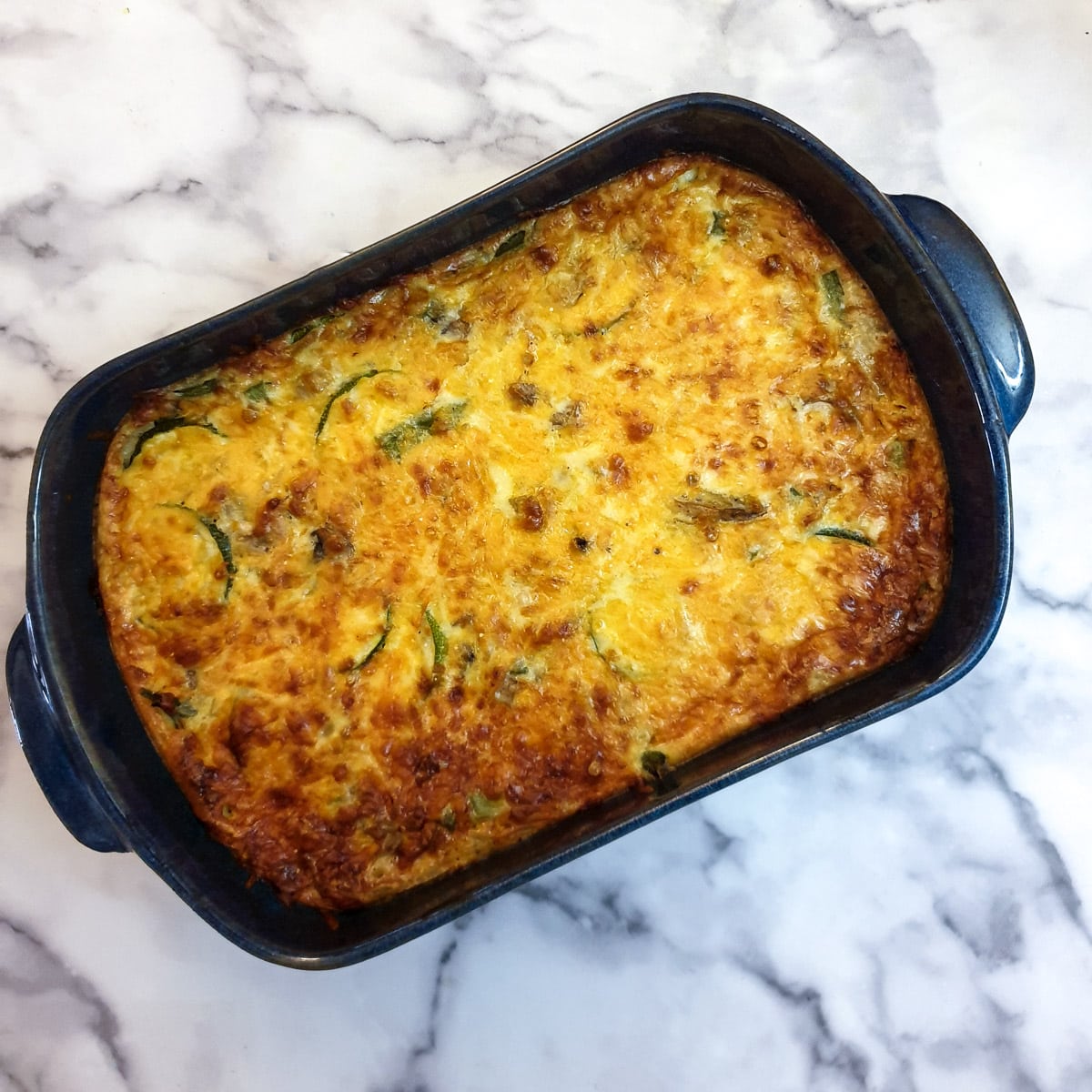 Crustless vegetable quiche in a blue baking dish.