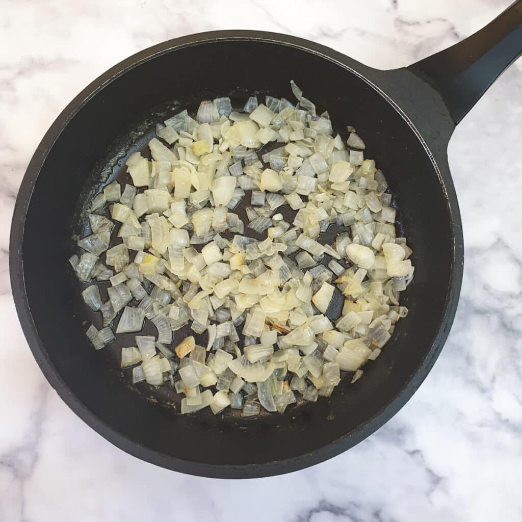 Chopped onions and garlic in a frying pan.