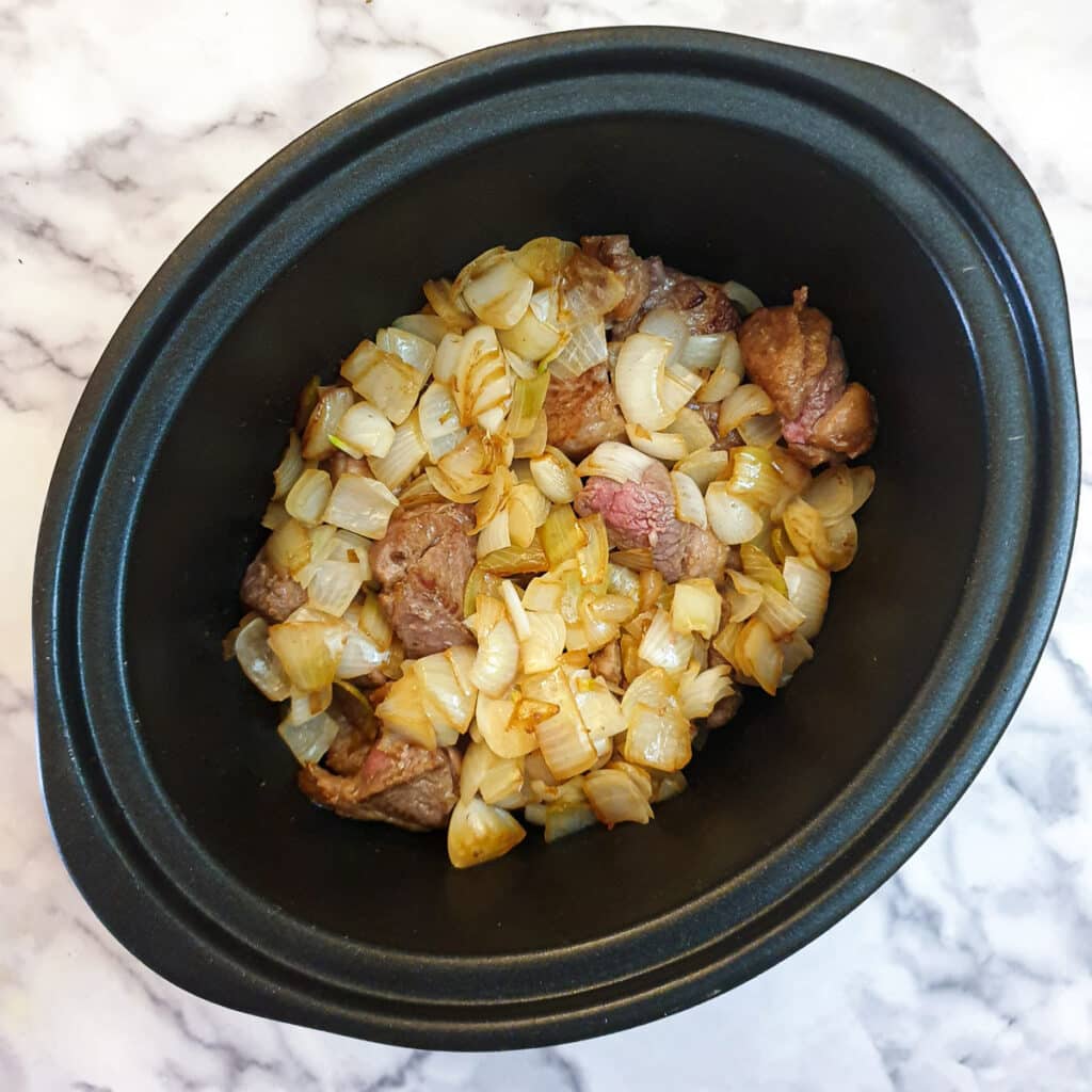 Onions added to lamb in a slow cooker