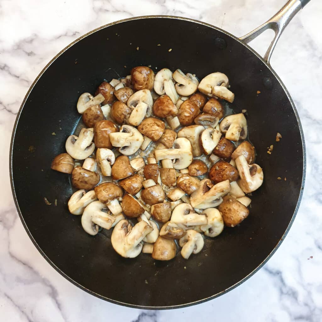 Cooked mushrooms in a frying pan.