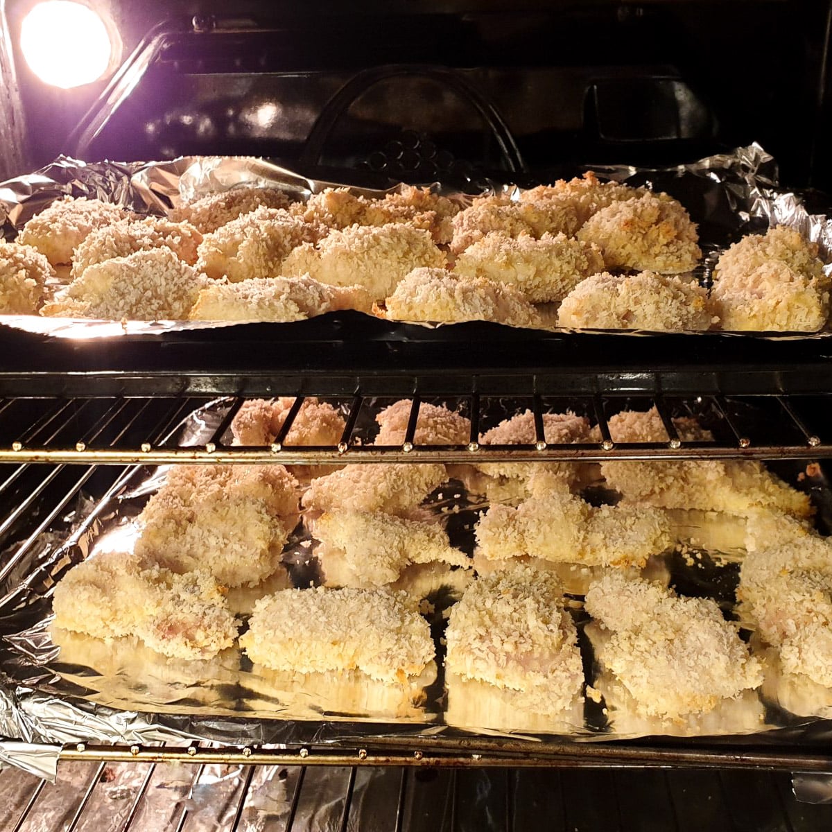 2 trays of chicken pieces in the oven.